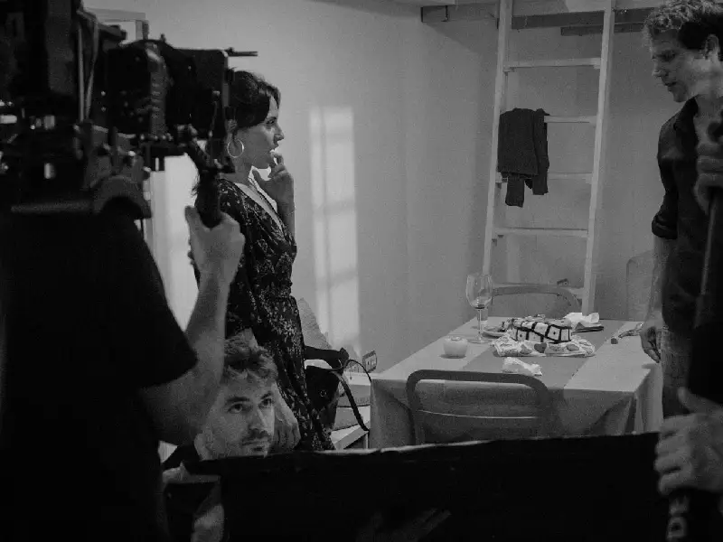 Detalle de cámara grabando una escena de un hombre y una mujer enfrentados a una mesa